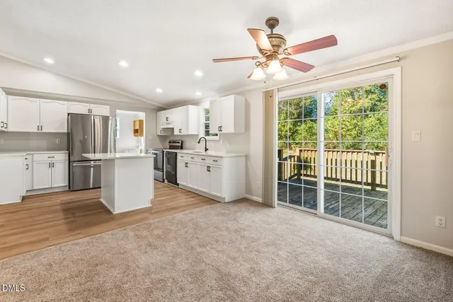 a view of a kitchen with wooden floor and a ceiling fan