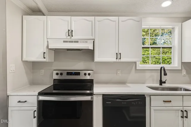 a kitchen with cabinets appliances a sink and a window