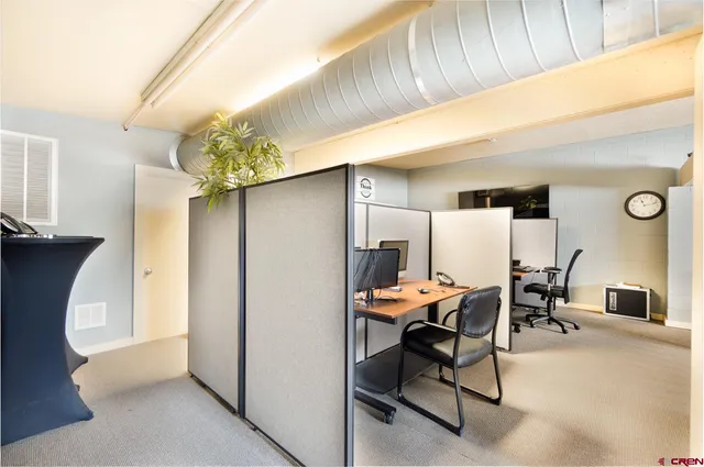 a view of a hallway with workspace and living room