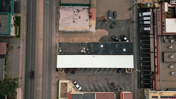 an aerial view of a large building with cars parked