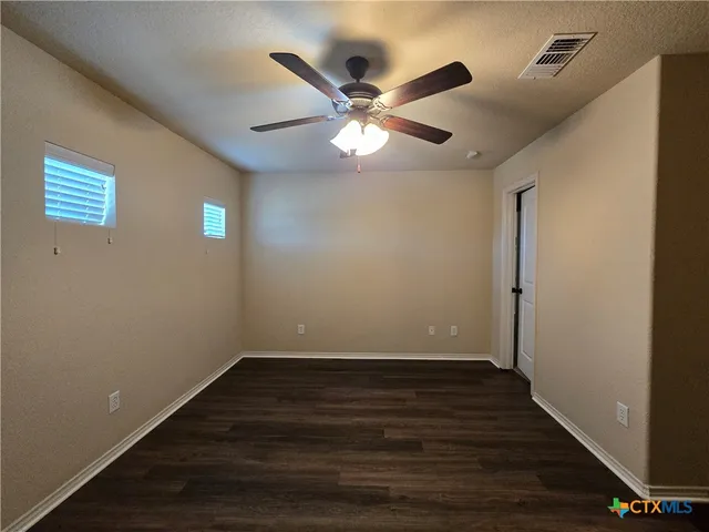 a view of an empty room with wooden floor