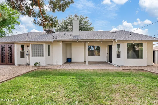 a view of a house with a yard and large tree
