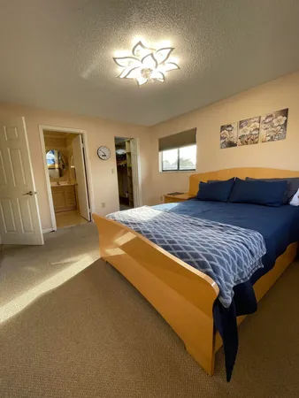 a spacious bedroom with a bed and a chandelier