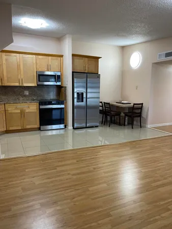 a view of a kitchen with stainless steel appliances wooden floor and a counter top space