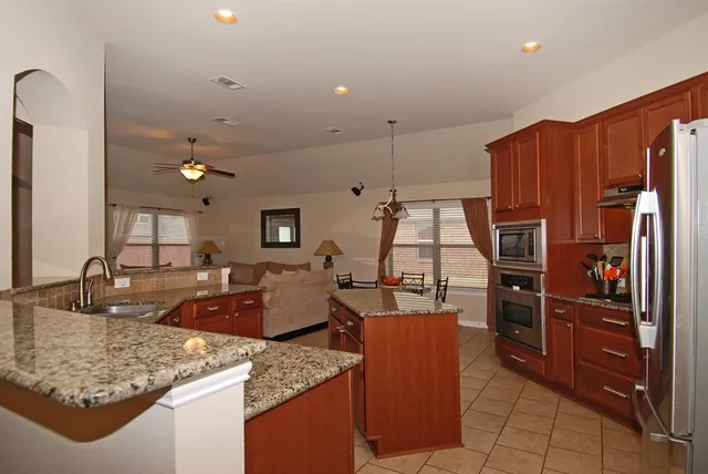 a kitchen with stainless steel appliances granite countertop a sink dishwasher stove and refrigerator