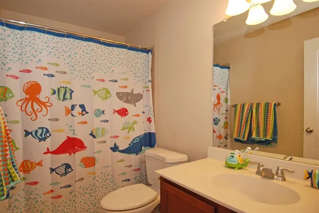 a bathroom with a sink toilet and a mirror