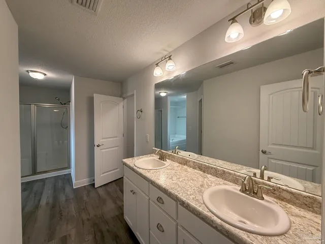a bathroom with a granite countertop sink a light fixture and a mirror