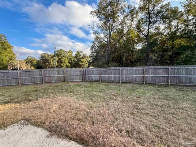 a view of yard with trees in the background