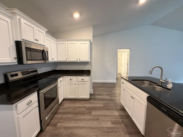 a kitchen with a sink stove and microwave