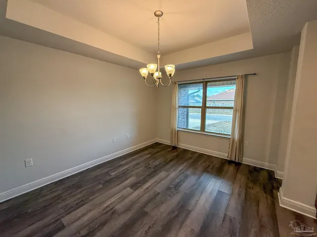 a view of a room with wooden floor chandelier and window