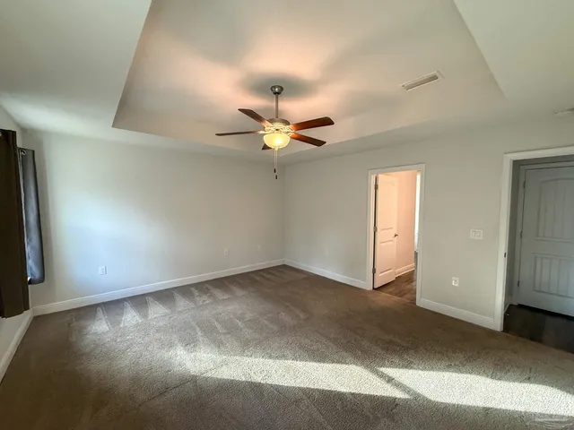 an empty room with a ceiling fan and a window