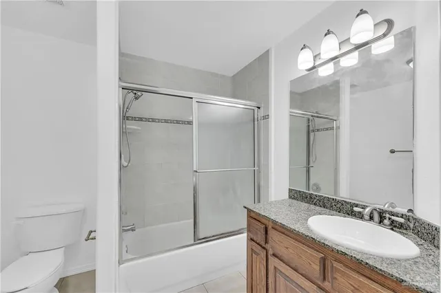a bathroom with a granite countertop sink a mirror and a shower