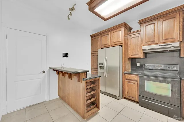 a kitchen with stainless steel appliances granite countertop a refrigerator and a stove top oven