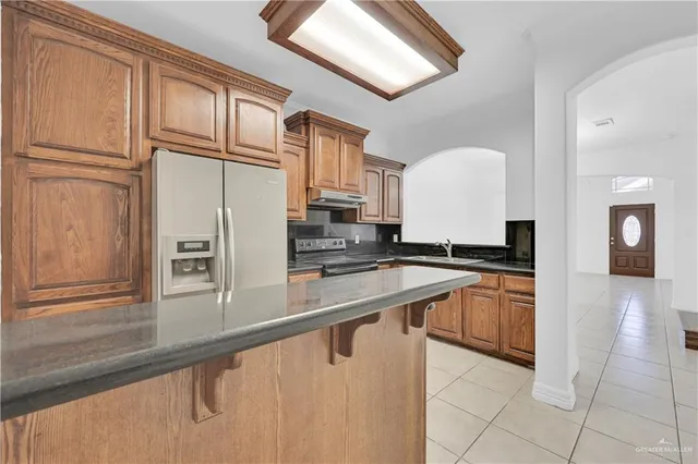 a kitchen with stainless steel appliances granite countertop a sink and a refrigerator