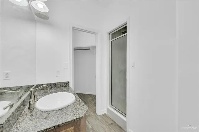 a bathroom with a granite countertop sink and a mirror
