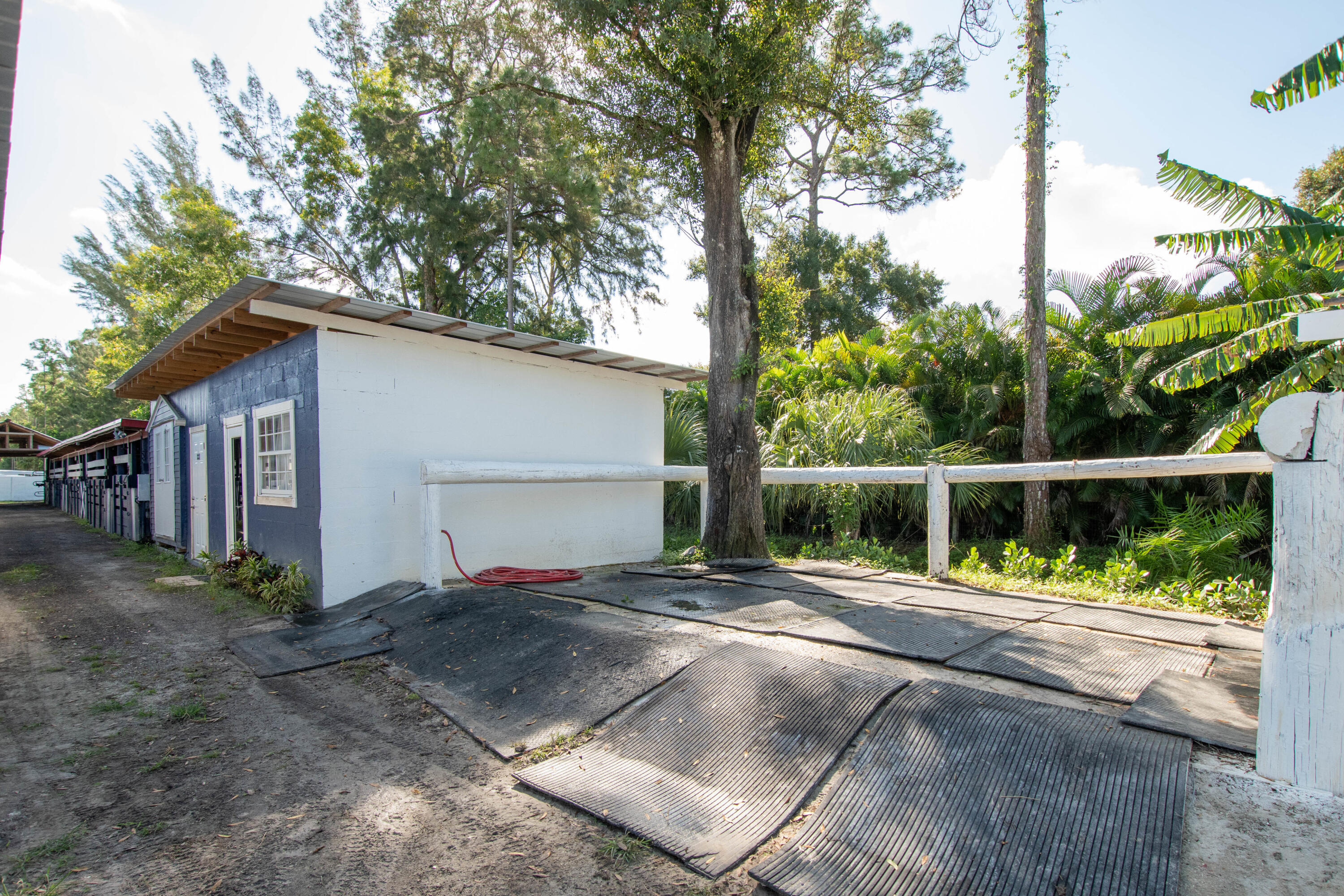 1044 D Road Loxahatchee Groves, FL 33470 - Photo 22 of 36 a view of a small house with wooden fence next to a road