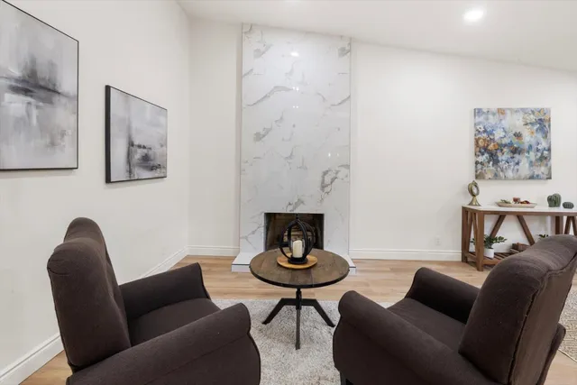 a living room with furniture a flat screen tv and a table