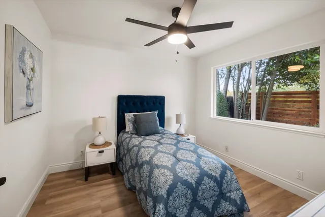 a bedroom with a bed and a painting on the wall
