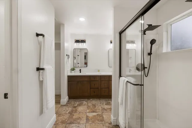a bathroom with a double vanity sink a mirror and shower