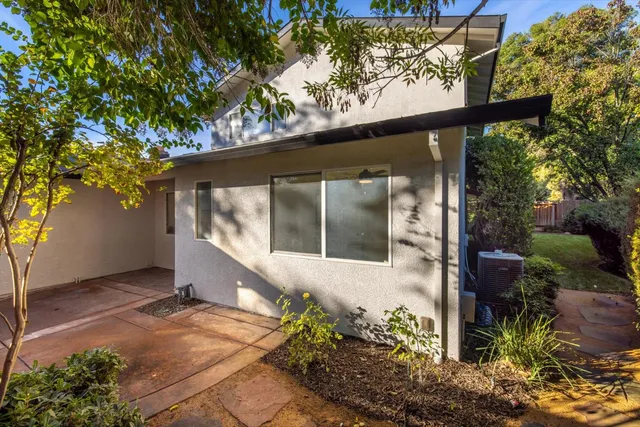 a view of a yard with plants and a barbeque