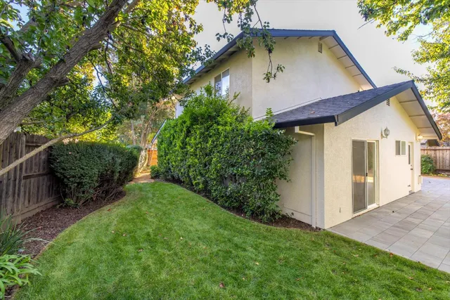 a view of backyard with a tub and wooden fence