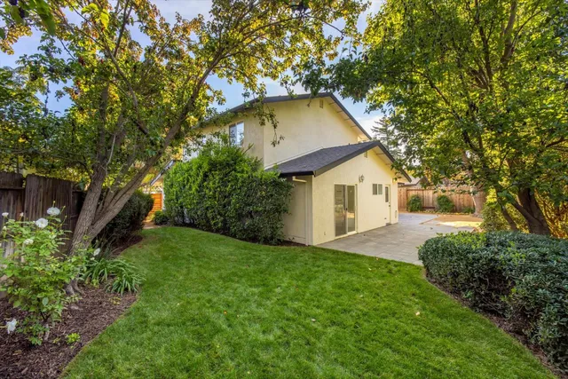 a view of a house with backyard and trees