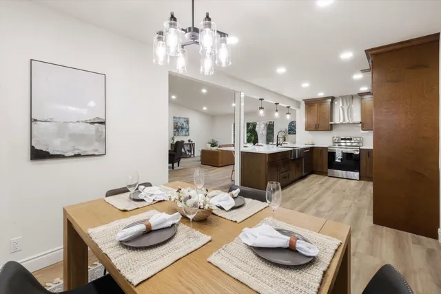 a large kitchen with a large counter top a sink stainless steel appliances and cabinets