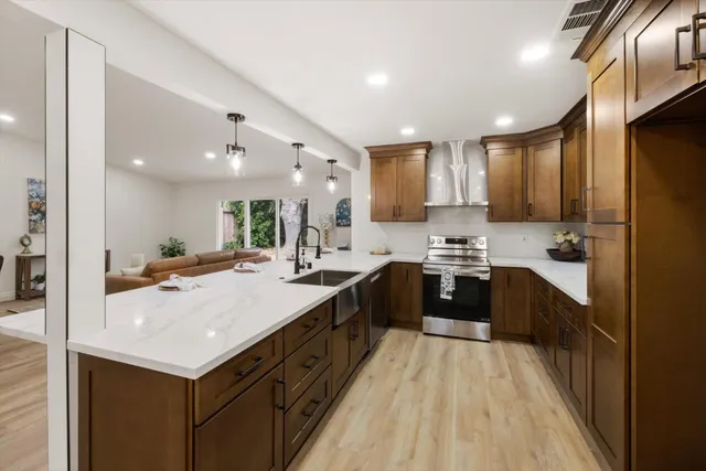 a kitchen with kitchen island stainless steel appliances a sink and chairs