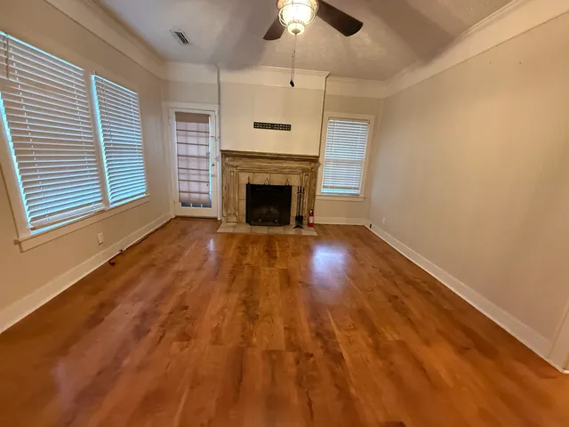 wooden floor fireplace and windows in an empty room