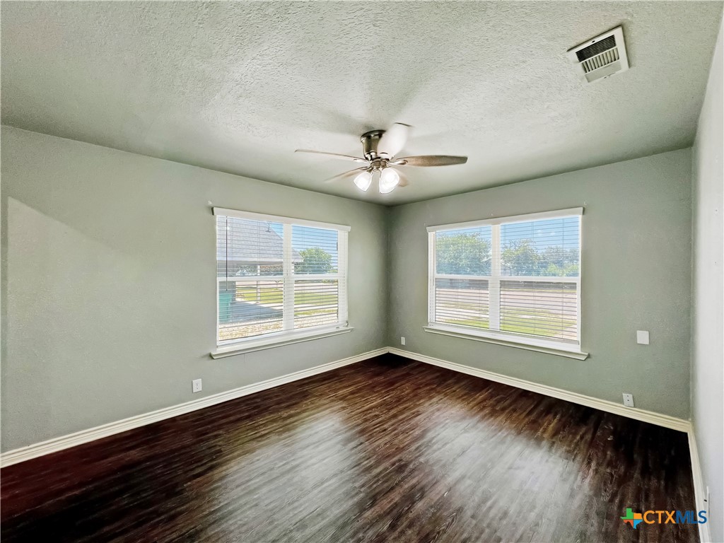 1311 West Main Street Gatesville, TX 76528 - Photo 16 of 30 a view of an empty room with wooden floor and a window