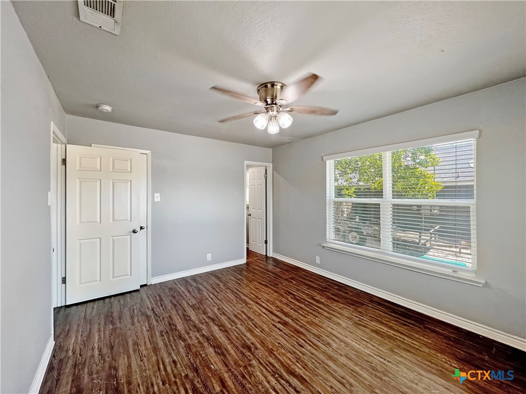 1311 West Main Street Gatesville, TX 76528 - Photo 17 of 30 a view of an empty room with wooden floor and a window