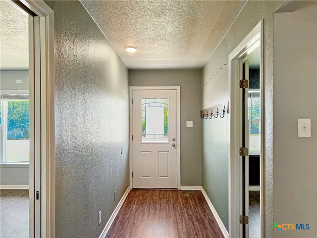 a view of a hallway with wooden floor