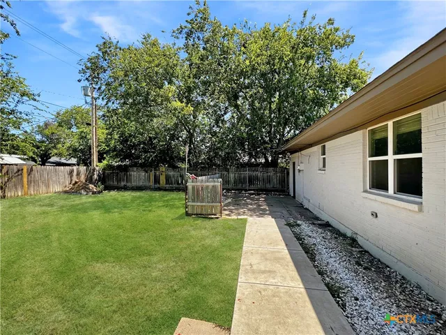 a view of house with backyard and sitting area