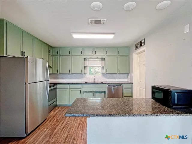 a kitchen with a refrigerator and a sink