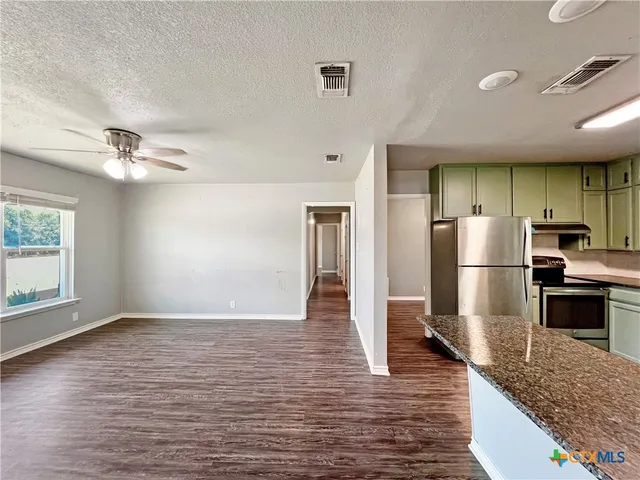 a kitchen with stainless steel appliances a refrigerator and a stove top oven