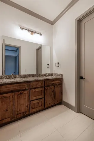 a bathroom with a granite countertop double vanity sink and a mirror