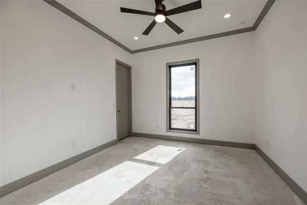 an empty room with windows and fan