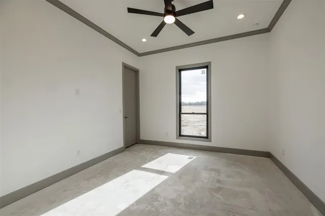 an empty room with windows and fan