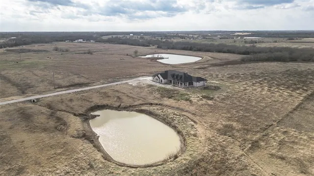 a view of a dry yard with wooden fence