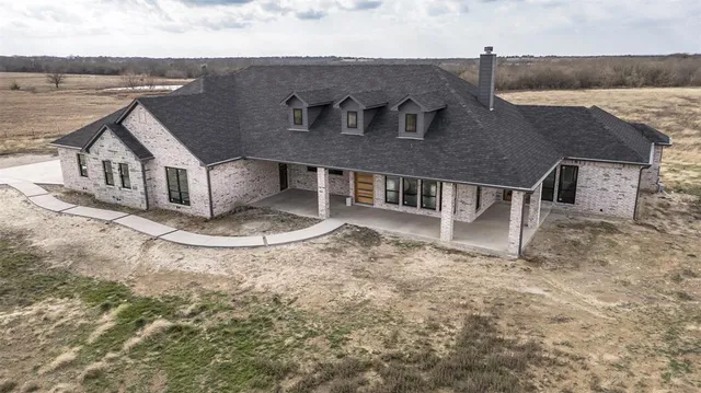 an aerial view of a house with a yard and balcony
