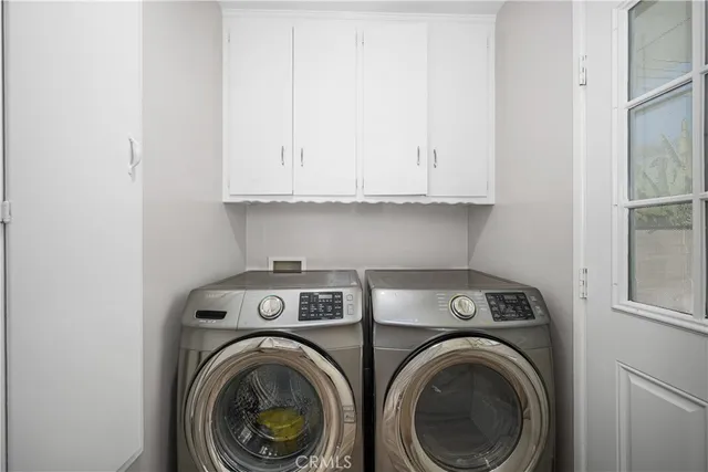 a kitchen with white cabinets and appliances