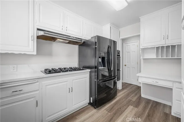 a kitchen with stainless steel appliances a sink cabinets and wooden floor