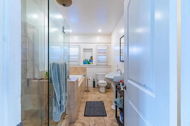 a bathroom with a sink a toilet and a mirror