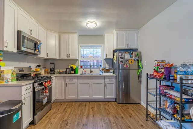 a kitchen with stainless steel appliances granite countertop a refrigerator and a stove top oven