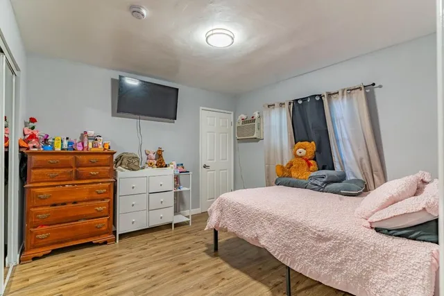 a bedroom with a bed and wooden floor