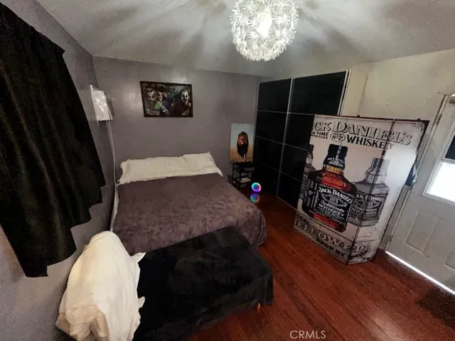 a bedroom with bed and a flat tv screen on the dresser