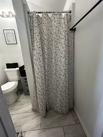 a bathroom with a toilet and a shower curtain