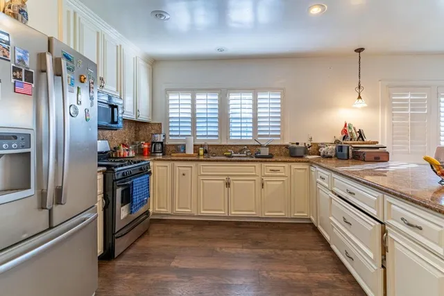 a kitchen with a refrigerator and white cabinets
