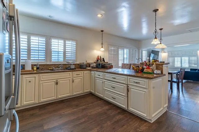 a kitchen with stainless steel appliances kitchen island granite countertop a stove a sink a center island and a window