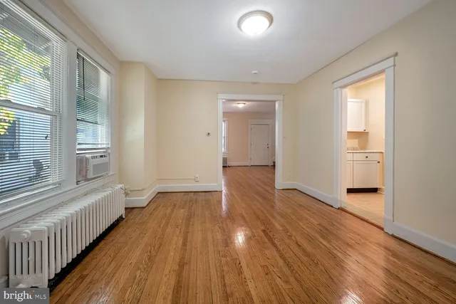 a view of a room with wooden floor and white walls